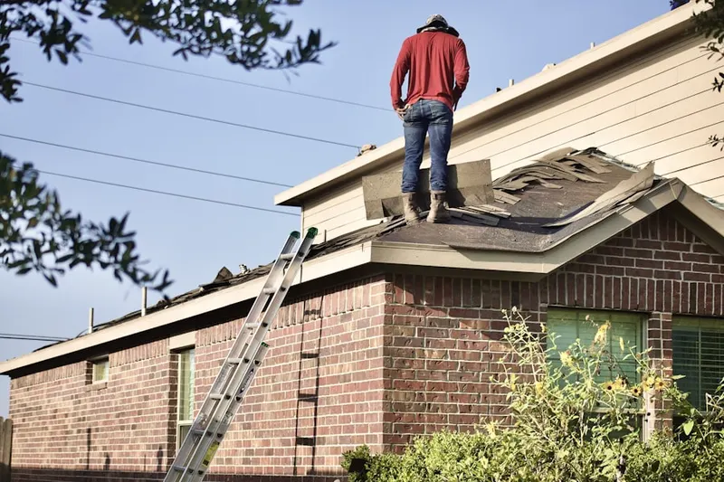Professional roofer working on a residential roof in West Samoset